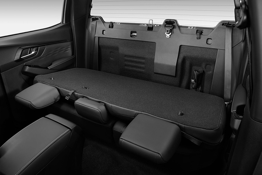 Baksätet i Isuzu D-Max med stolarna fällda – visar en plan lastyta för flexibel invändig transport.