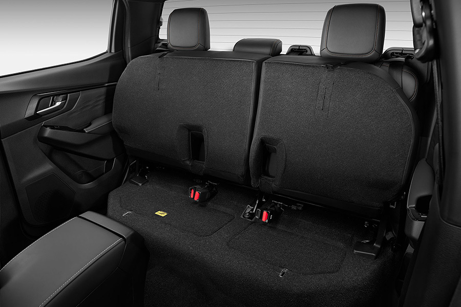 Baksätet i Isuzu D-Max med båda sittdynorna uppfällda – visar det praktiska förvaringsutrymmet under sätet.