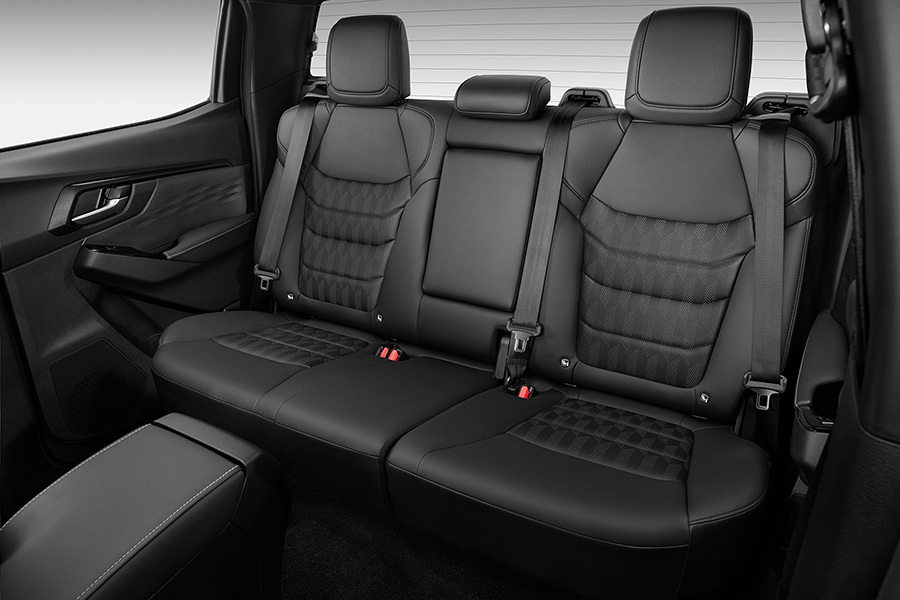 Närbild på baksätet i Isuzu D-Max – tre sittplatser med nedfällbart armstöd i mitten för ökad komfort.