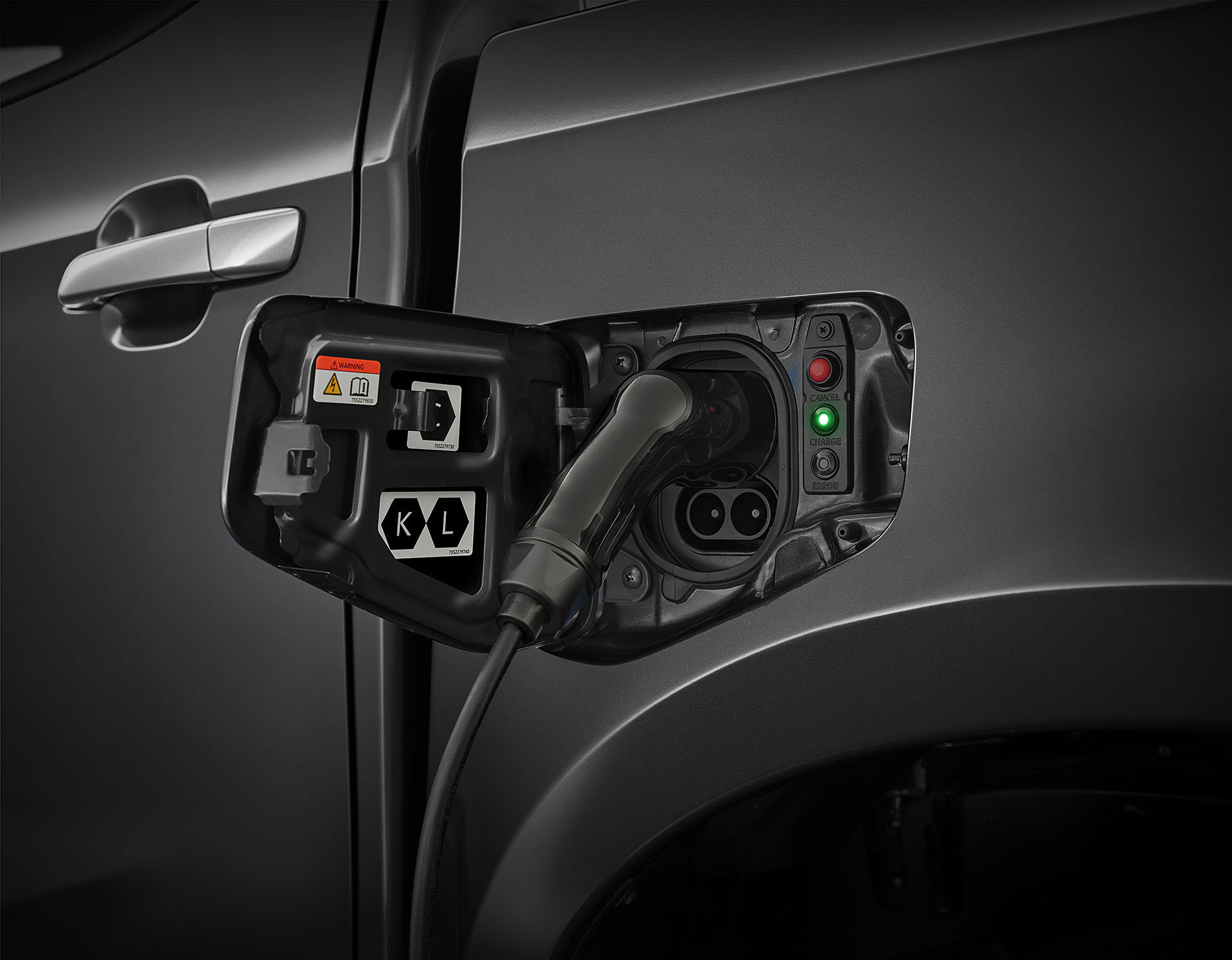 Isuzu D-Max BEV – närbild på laddningsuttaget med laddhandske inkopplad och grön indikatorlampa som visar att laddning pågår.