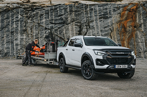 Vit Isuzu D-Max Double Cab med släpvagn kopplad framför en bergvägg – lastad med en 3,5 tons hydraulhammare.