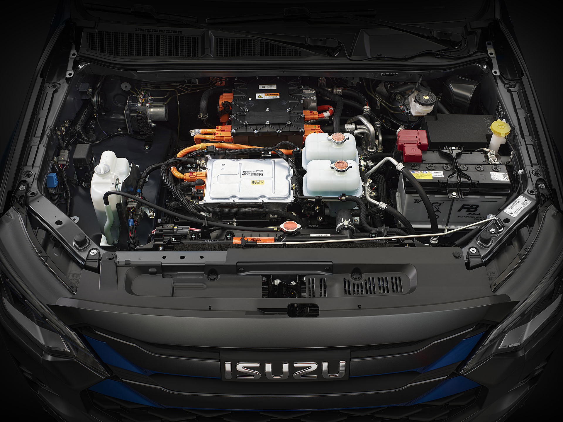 Isuzu D-Max BEV – närbild under huven som visar komponenter som batteri, kylarvätska och elsystemets installation.